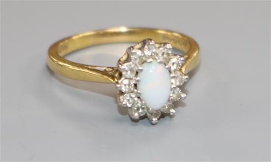 A modern 18ct gold, white opal and diamond cluster ring, size O.